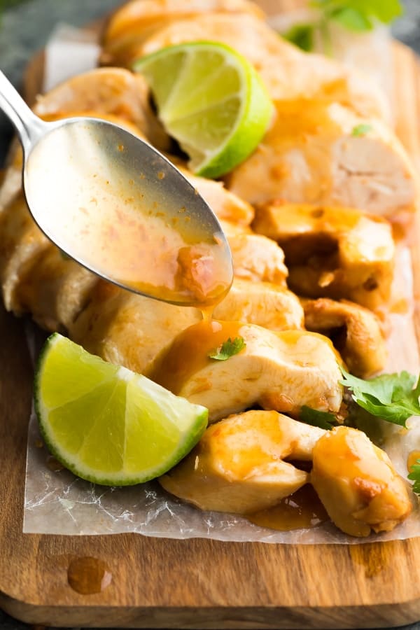 Instant Pot Chipotle Lime Chicken Breasts on cutting board with spoon dripping sauce