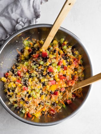 Quinoa Black Bean Salad in a large bowl with two wooden tongs