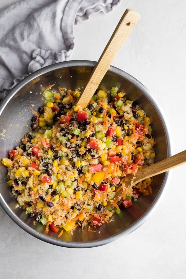 Quinoa Black Bean Salad in a large bowl with two wooden tongs