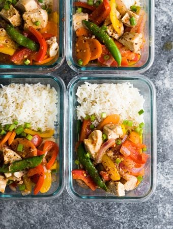 overhead shot of four coconut sweet chili chicken stir fry bowls in glass meal prep containers
