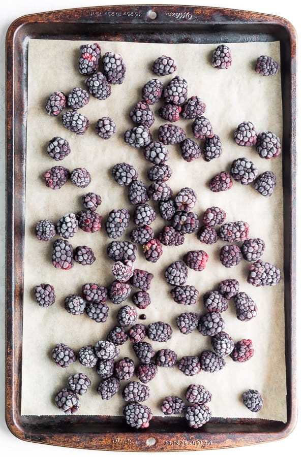 How to Freeze Blackberries: frozen blackberries spread out on baking sheet