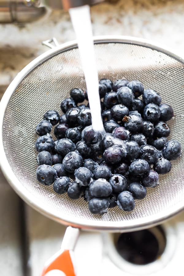 blueberries in a sieze under running tap