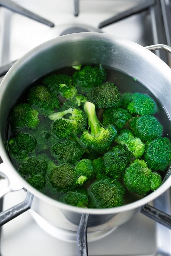 broccoli florets in a pot of water on the stove