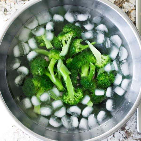 overhead shot of broccoli florets in an ice bath
