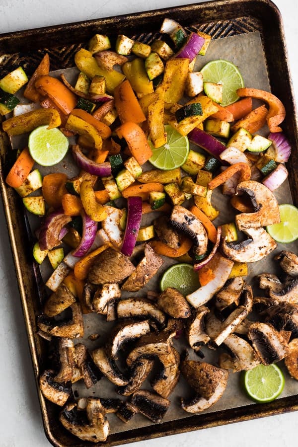 portobello mushrooms, zucchini, red onion, and lime wedges on sheet pan