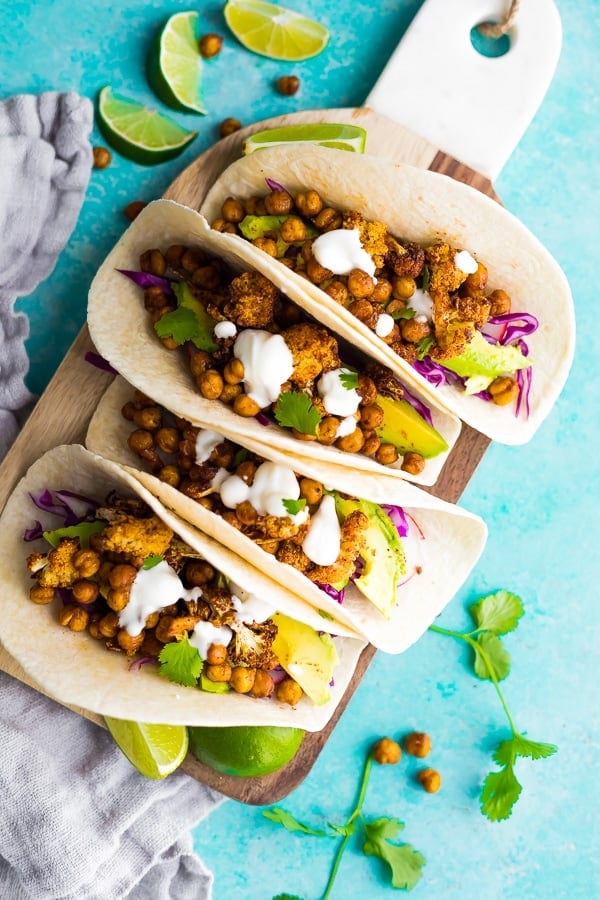 Air Fryer Cauliflower Chickpea Tacos on cutting board with blue background