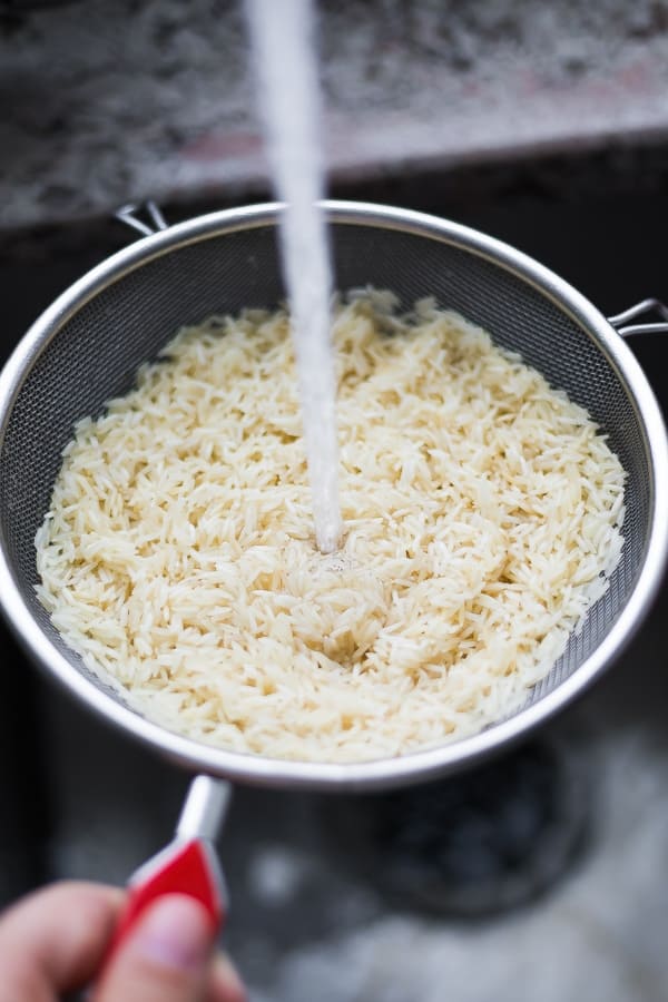 rinsing rice in a colander under the tap