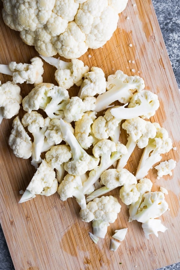 cauliflower florets on wooden cutting board from above
