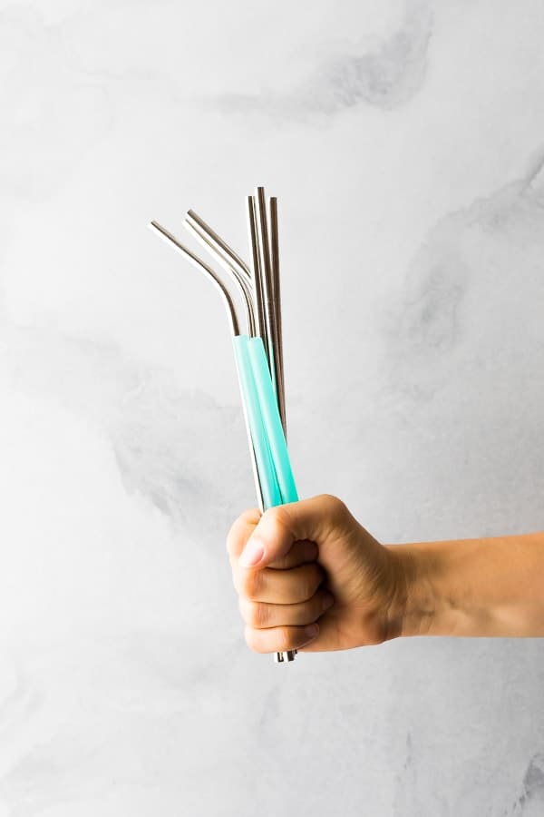 hand holding up multiple stainless steel straws