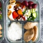 overhead shot of glass meal prep container with no cook greek pita bento and salad