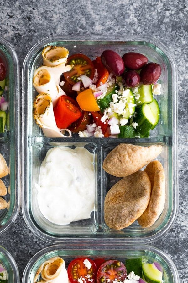 overhead shot of glass meal prep container with no cook greek pita bento and salad