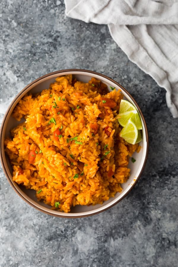 overhead shot of mexican rice in a brown bowl with gray background