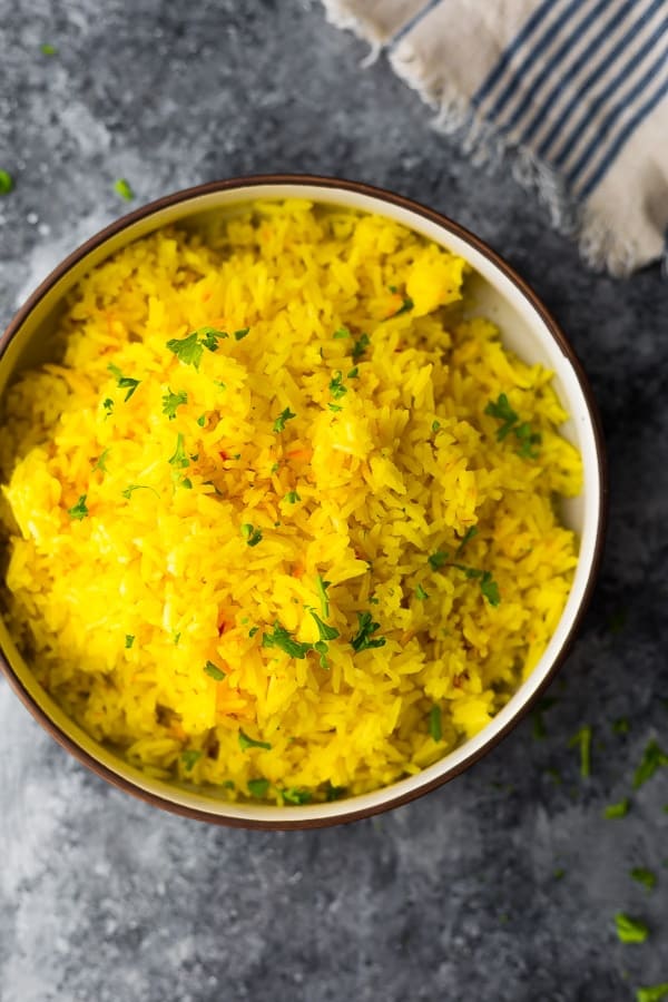 bowl of saffron yellow rice on grey background