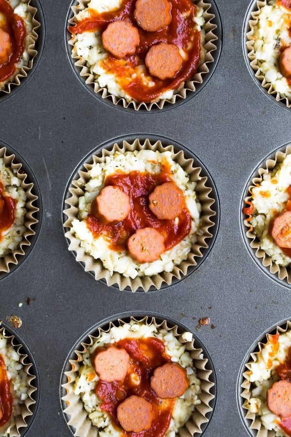 low carb cauliflower pizza muffins before baking, in muffin tins