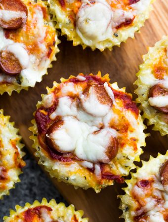 overhead shot of multiple cauliflower pizza muffins on wood board