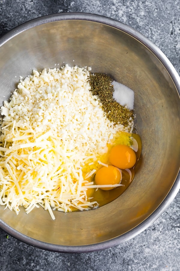 ingredients for low carb cauliflower pizza muffins in a metal bowl