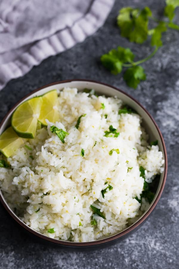 lime cilantro rice in brown bowl on grey background