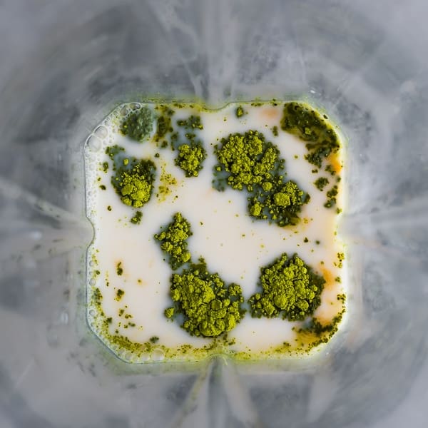 ingredients for a matcha green tea latte in a blender