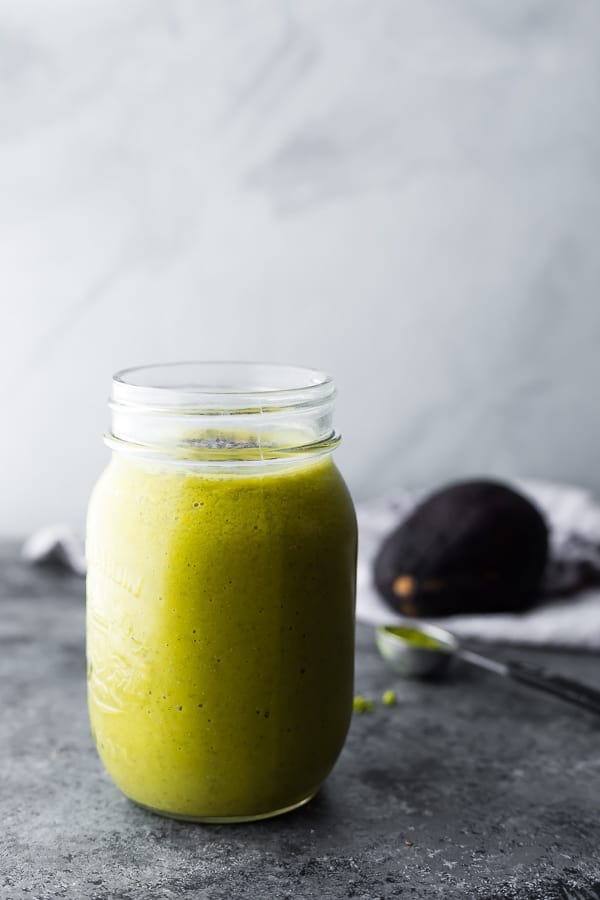 Matcha Avocado Smoothie in mason jar with avocado in background