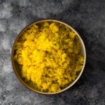 overhead shot of turmeric yellow rice in bowl on gray background