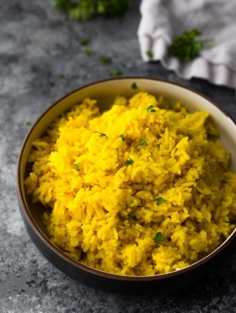 side view of turmeric yellow rice in black bowl