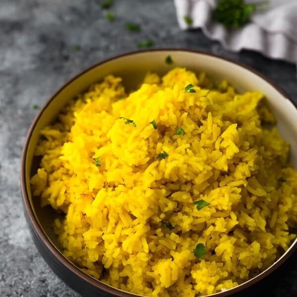side view of turmeric yellow rice in black bowl