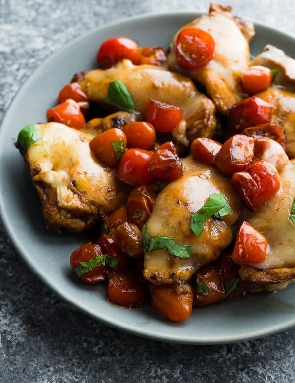 caprese instant pot chicken thighs on a gray plate with basil