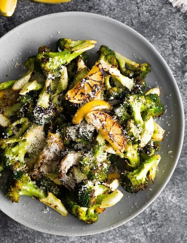 Overhead view of Grilled Broccoli with Lemon and Parmesan in a gray bowl