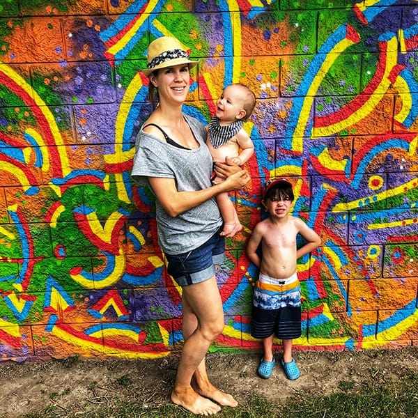 Denise with her two kids in front of a mural wall