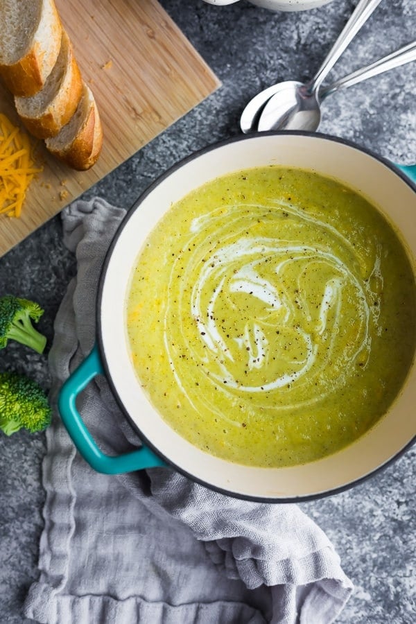 overhead view of the pot with pureed broccoli cheese soup swirled with yogurt