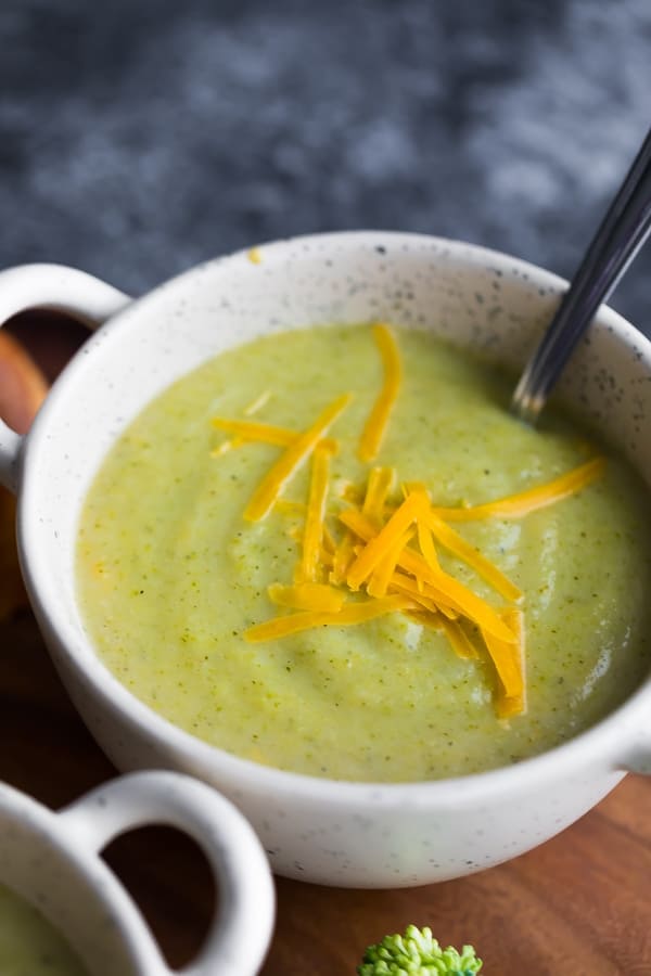 close up view of the broccoli cheese soup in white bowl