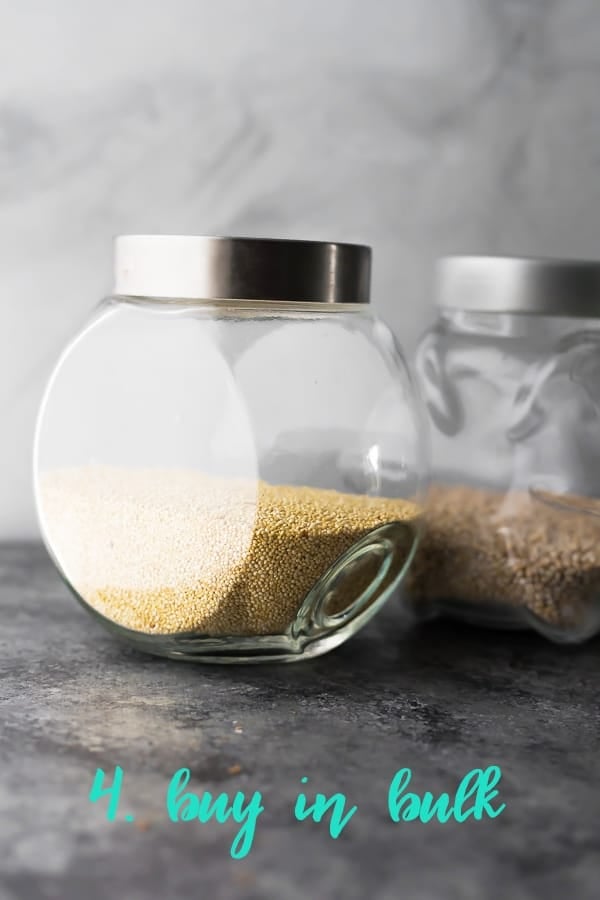 close up shot of grains in a glass jar with text buy in bulk