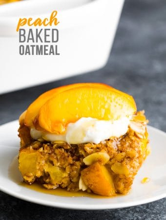 side view of peach baked oatmeal on a white plate with fresh peaches on top