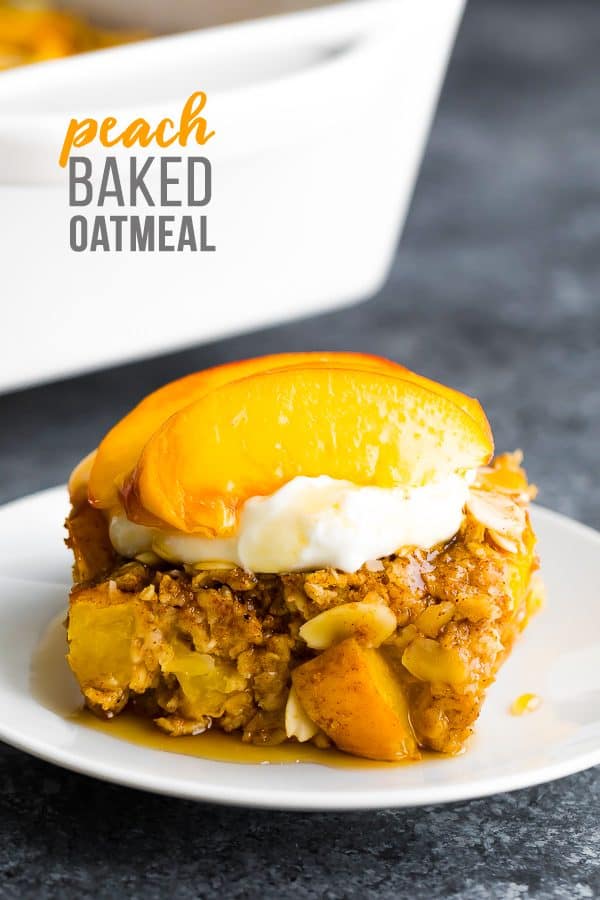 side view of peach baked oatmeal on a white plate with fresh peaches on top