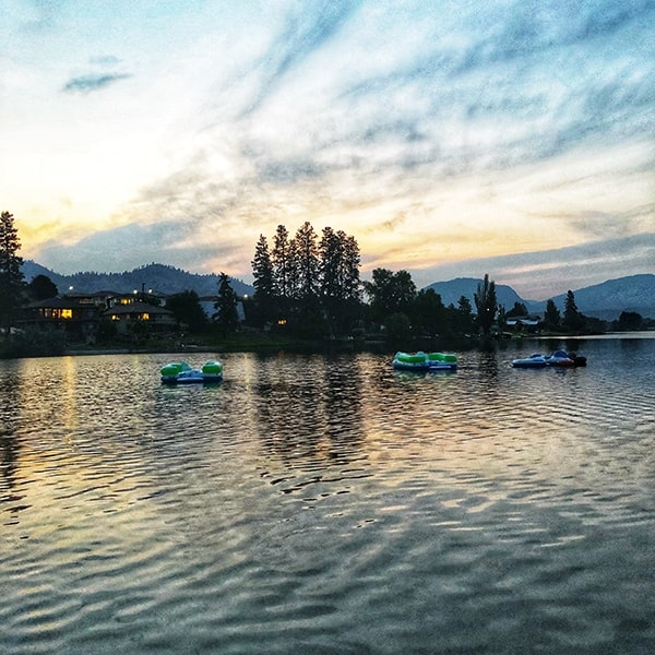 a lake at sunset with mountains in background