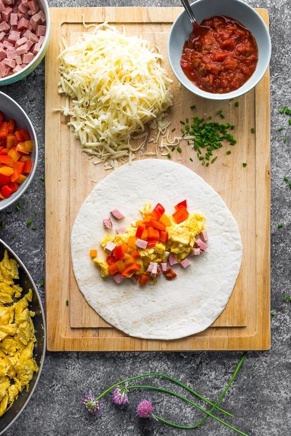 ingredients and partially assembled freezer breakfast burritos