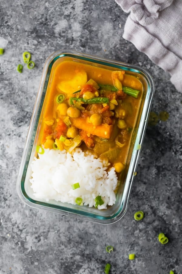 chickpea coconut curry in a meal prep container with rice.