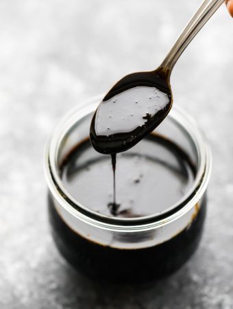 spoon of balsamic reduction over a mason jar