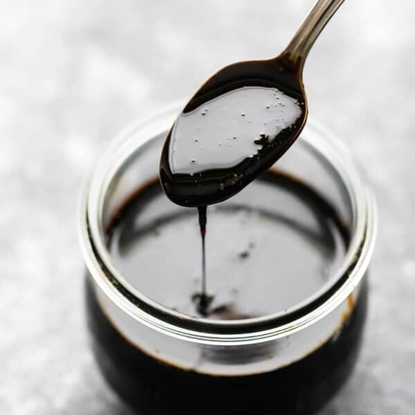 spoon of balsamic reduction over a mason jar