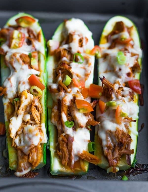 three pulled pork stuffed zucchini boats in a row