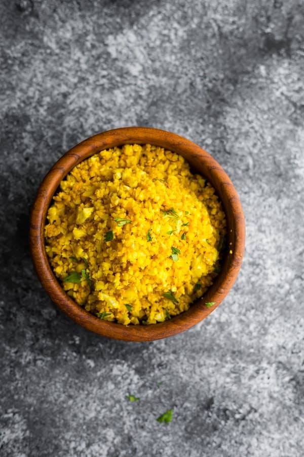 golden turmeric cauliflower rice in brown bowl