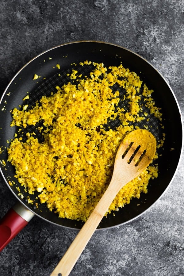 cooking golden turmeric cauliflower rice in pan