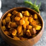 maple cinnamon roasted butternut squash in wood bowl on gray background