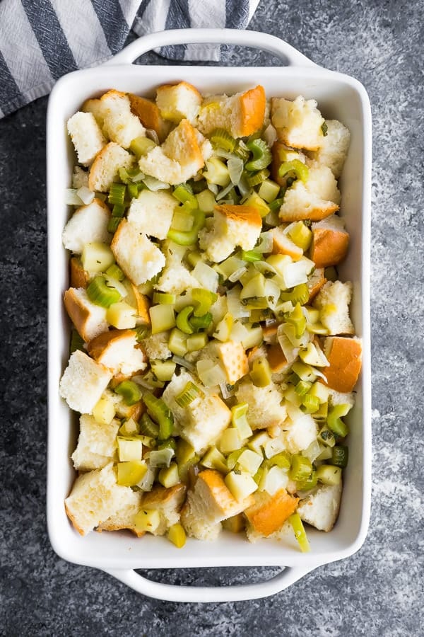 sage apple stuffing in white dish before baking