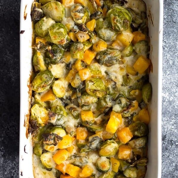 overhead shot of brussels sprouts gratin with butternut squash in white dish