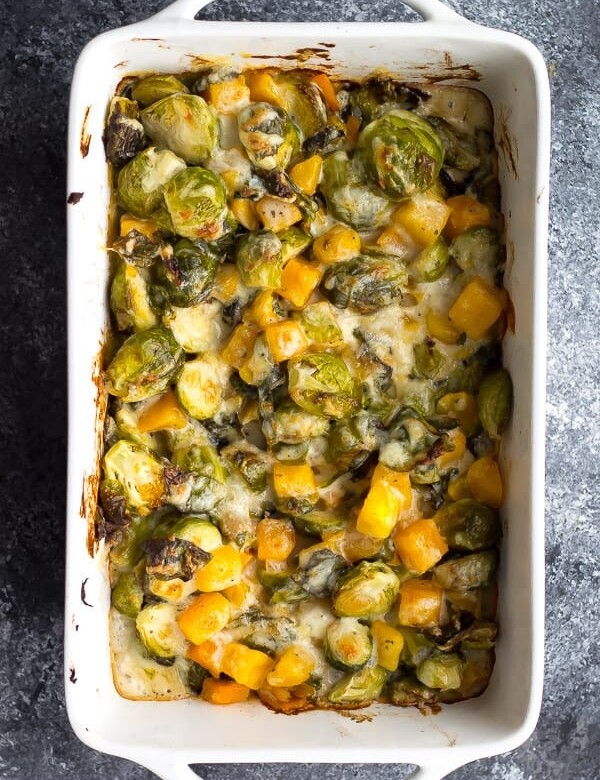 overhead shot of brussels sprouts gratin with butternut squash in white dish