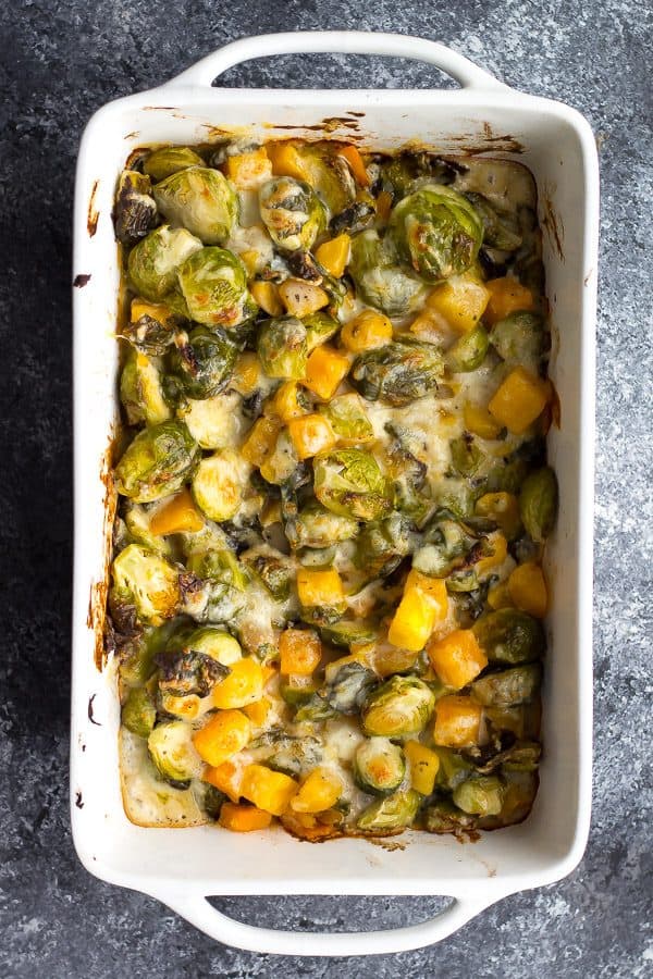 overhead shot of brussels sprouts gratin with butternut squash in white dish