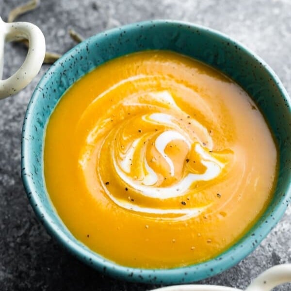 butternut squash soup in blue bowl on gray background