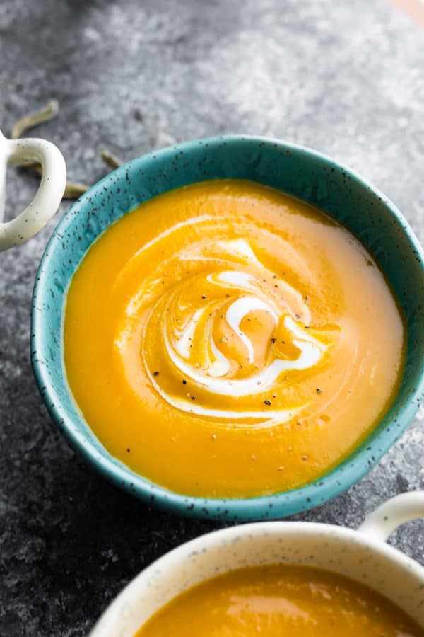 butternut squash soup in blue bowl on gray background