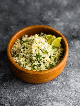side view of cilantro lime cauliflower rice in wood bowl